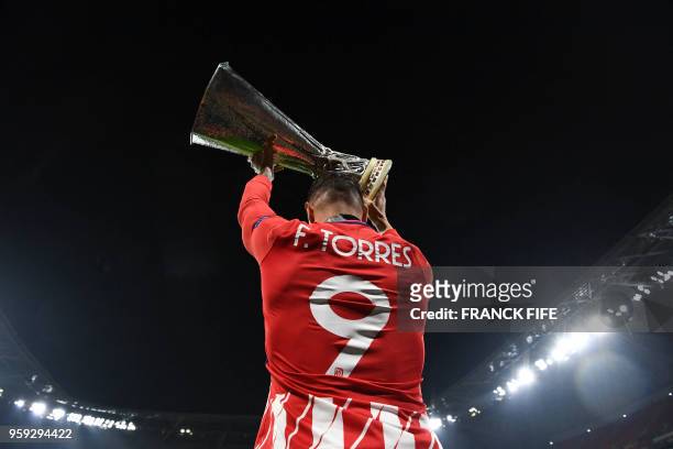 Atletico Madrid's Spanish forward Fernando Torres celebrates with the trophy after the UEFA Europa League final football match between Olympique de...