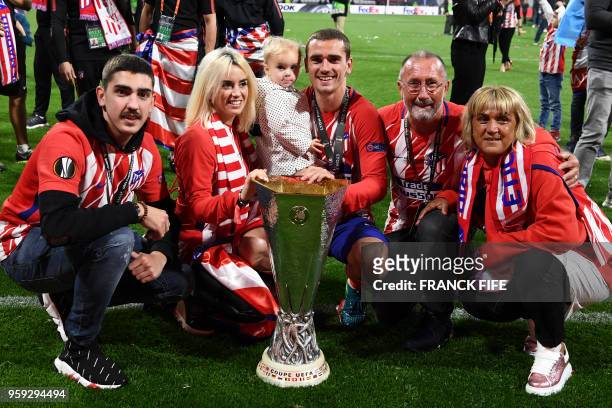 Atletico Madrid's French forward Antoine Griezmann celebrates with the trophy with his family, his brother Théo Griezemann, his wife Erika Choperana,...