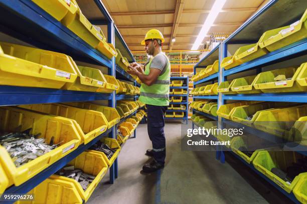 manual worker in a spare part warehouse in a factory - spare parts stock pictures, royalty-free photos & images