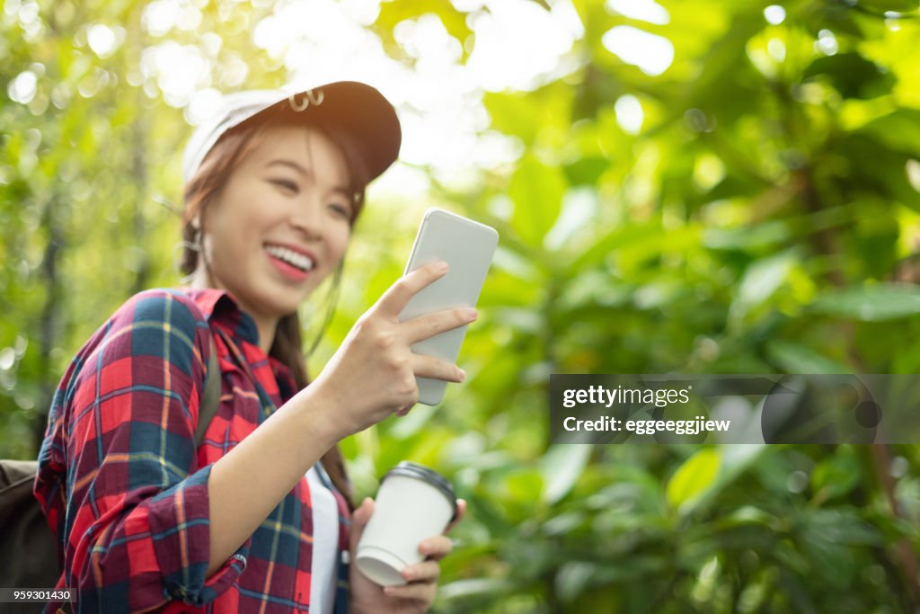 Relaxed Asian girl using digital map with smartphone.