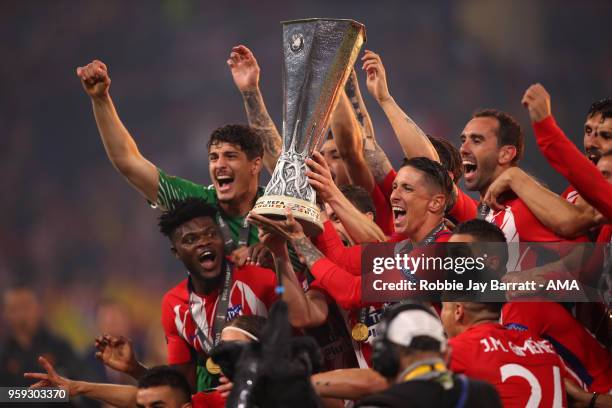 Gabi and Fernando Torres of Atletico Madrid lift the trophy with their team-mates at the end of the UEFA Europa League Final between Olympique de...