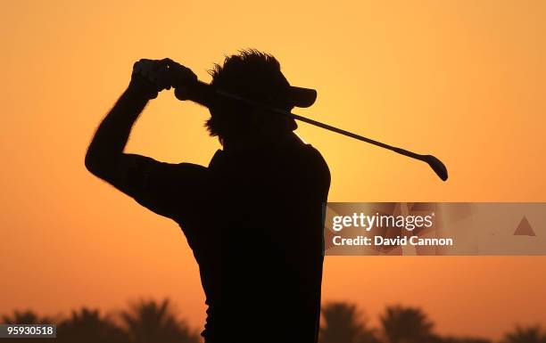 Ian Poulter of England warms up on the practice ground against the rising desert sun before he teed off during the second round of The Abu Dhabi Golf...