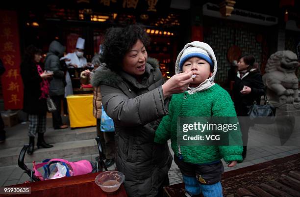 Mother feeds her child free Laba porridge on January 21, 2010 in Shanghai of China. The traditional Laba Festival falls on the 8th day of the 12th...