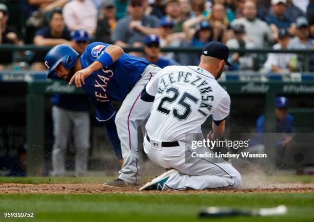 Isiah Kiner-Falefa of the Texas Rangers beats the tag from Marc Rzepczynski of the Seattle Mariners to score in the ninth inning at Safeco Field on...