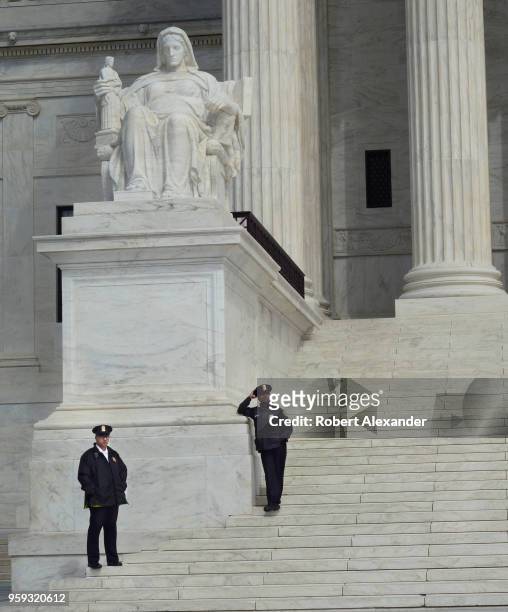 Two police officers stand guard at the entrance to he U.S. Supreme Court Building in Washington, D.C., the seat of the Supreme Court of the United...