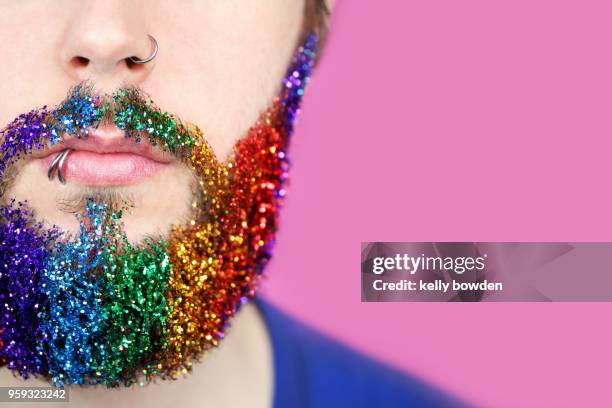 gay pride man with rainbow glitter beard - regenbogenfahne stock-fotos und bilder