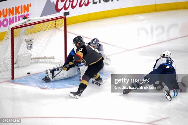 Jonathan Marchessault of the Vegas Golden Knights skates past Jacob Trouba to score a goal past Connor Hellebuyck of the Winnipeg Jets during the...