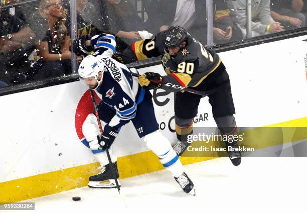 Josh Morrissey of the Winnipeg Jets is checked by Tomas Tatar of the Vegas Golden Knights during the first period in Game Three of the Western...