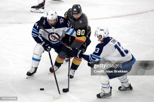 Brandon Tanev skates as teammate Josh Morrissey of the Winnipeg Jets battles for the puck with Tomas Tatar of the Vegas Golden Knights during the...