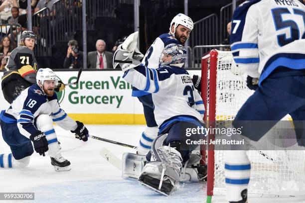 Connor Hellebuyck makes a save while his teammates Bryan Little and Dustin Byfuglien of the Winnipeg Jets defend against the Vegas Golden Knights in...