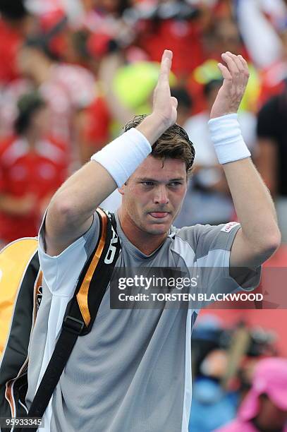Kazakh tennis player Evgeny Korolev applauds the crowd after defeat in his men's singles match against Chilean opponent Fernando Gonzalez on the...