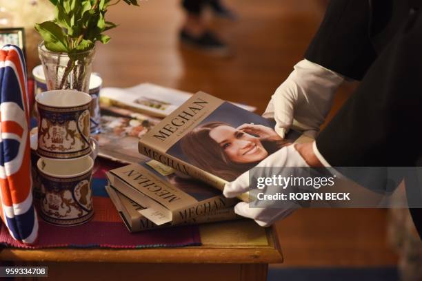 Member of the waitstaff adjusts a biography of Meghan Markle at The Rose Tree Cottage in Pasadena, north of Los Angeles, California, May 15 where...