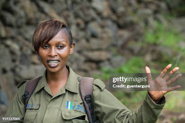 vrouwelijke nationaal park ranger op een gorilla trekking in rwanda - parkwachter stockfoto's en -beelden