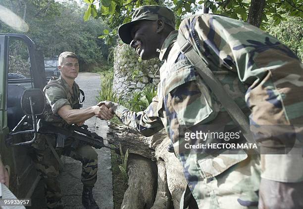 Soldier from the French Marines 33rd Regiment shake hands with Jean Hubert Marcelin a former rebel in Cap Haitien Haiti 21March 2004. Marcelin a...