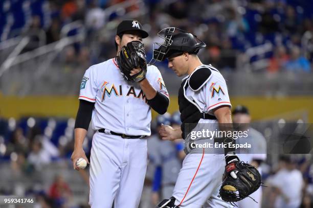 Junichi Tazawa of the Miami Marlins talks to catcher J.T. Realmuto during the sixth inning against the Los Angeles Dodgers at Marlins Park on May 16,...