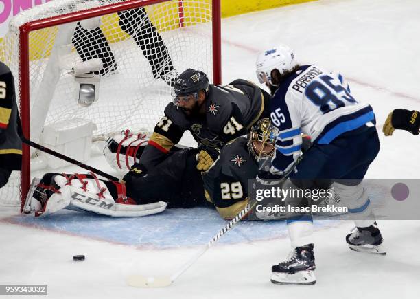 Mathieu Perreault of the Winnipeg Jets misses a shot on goal as Pierre-Edouard Bellemare falls on top of goalie Marc-Andre Fleury of the Vegas Golden...