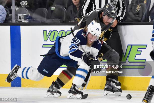 Ryan Carpenter of the Vegas Golden Knights and Patrik Laine of the Winnipeg Jets skate to the puck in Game Three of the Western Conference Final...