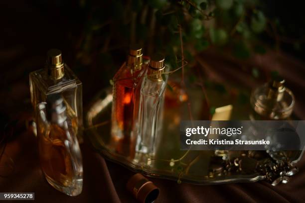 perfume bottles and a necklace on a silver tray - perfume atomizer stock pictures, royalty-free photos & images