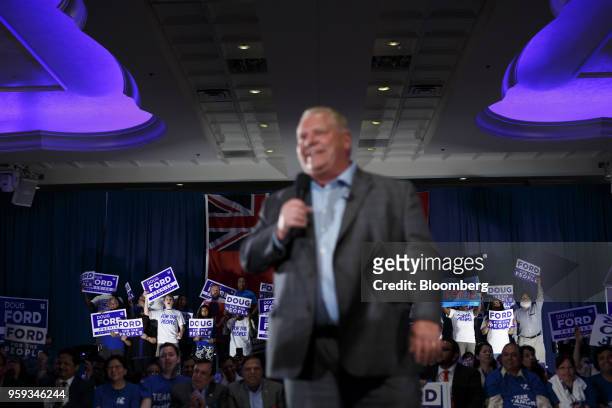 Attendees cheer and hold placards as Doug Ford, Progressive Conservative Party candidate for Ontario Premier, foreground, speaks during a campaign...