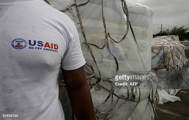 Volunteer for USAID stnads next to a shipment of humanitarian aid at the airport of Port-au-Prince in Haiti on January 2010. The number of people...