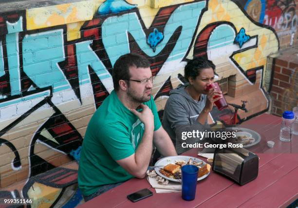 People enjoy the outside patio at 12 Bones Smokehouse barbecue restaurant in the River Arts District on May 11, 2018 in Asheville, North Carolina....