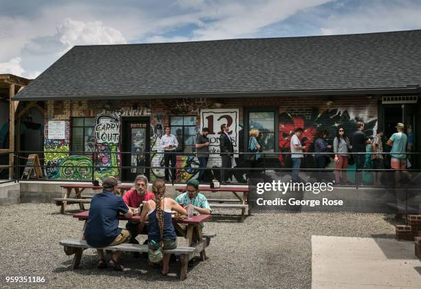 People enjoy the outside patio at 12 Bones Smokehouse barbecue restaurant in the River Arts District on May 11, 2018 in Asheville, North Carolina....