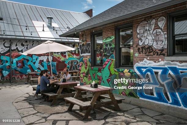 People enjoy the outside patio at 12 Bones Smokehouse barbecue restaurant in the River Arts District on May 11, 2018 in Asheville, North Carolina....