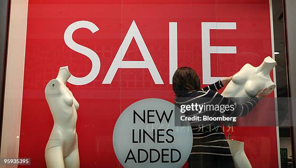 Mary White, a store manager moves mannequins in a window display at the Bluewater Shopping & Leisure Centre near Greenhithe, U.K., on Thursday, Jan....