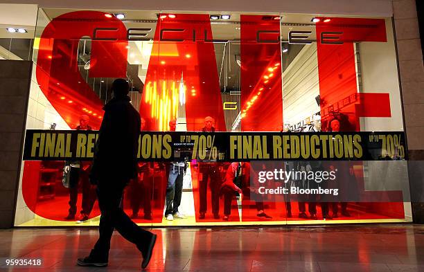 Shopper passes a store advertising a sales event at the Bluewater Shopping & Leisure Centre near Greenhithe, U.K., on Thursday, Jan. 21, 2010. U.K....