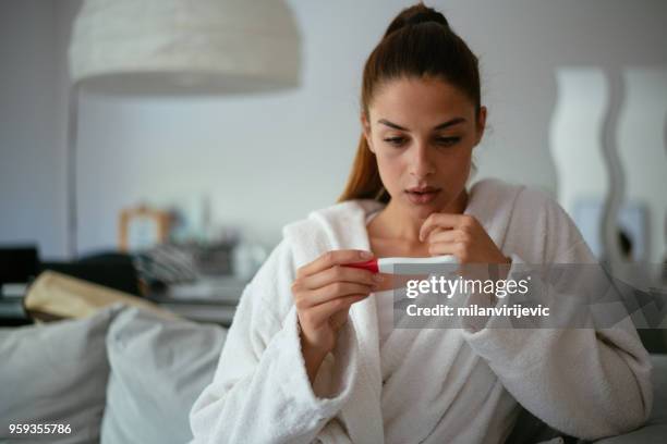 worried girl after looking a pregnancy test - pregnancy test stock pictures, royalty-free photos & images