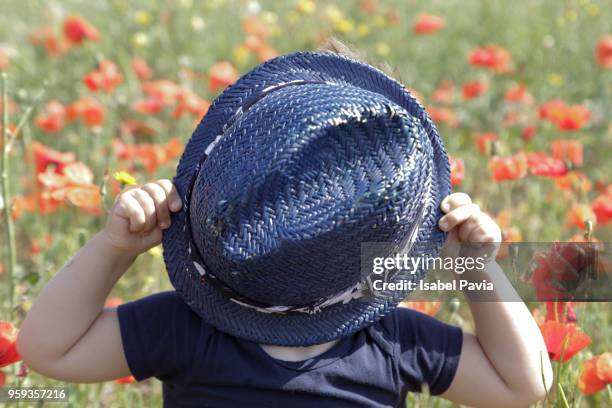 boy covering face with hat outdoors - isabel pavia stock-fotos und bilder