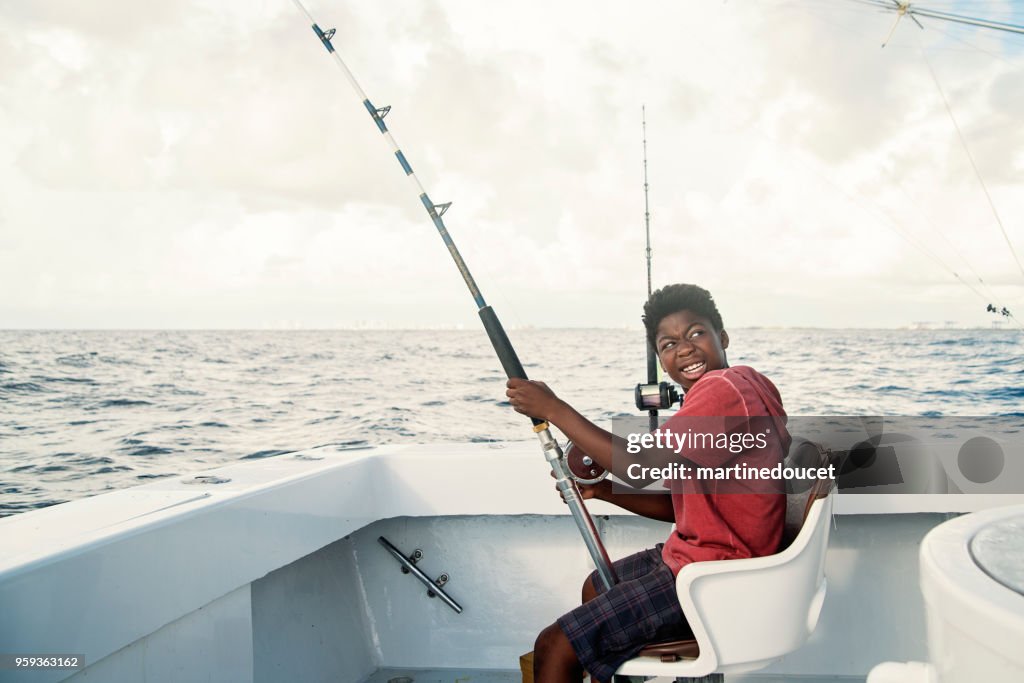 African-american boy on a sea fishing trip.
