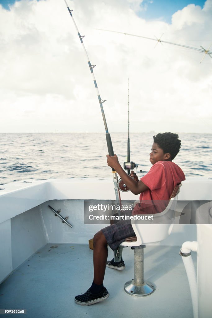 Afro-Amerikaanse jongen op een visreis van zee.