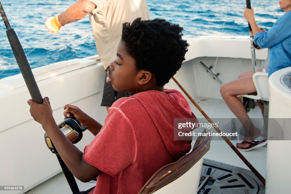 Menino Africano-americano em uma viagem de pesca de mar.