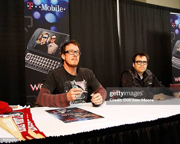 Scott Shriner and Rivers Cuomo of Weezer sign autographs before performing at the T-Mobile Motorola CLIQ Challenge Concert on January 20, 2010 in...