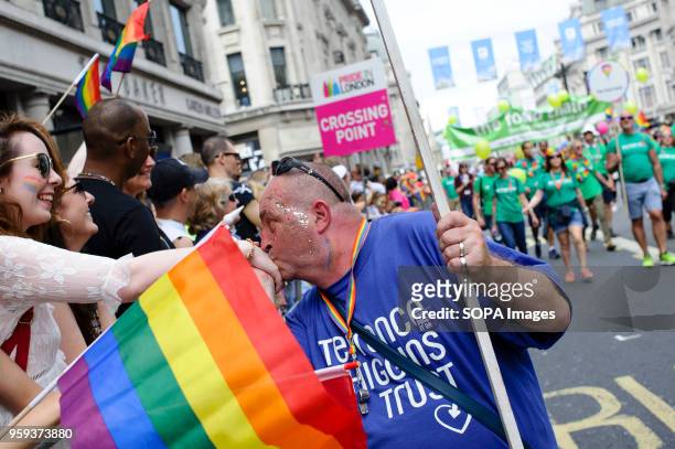 Marcher representing HIV charity the Terrence Higgins Trust kisses a spectator's hand on Regent Street during the 2017 Pride in London Parade through...