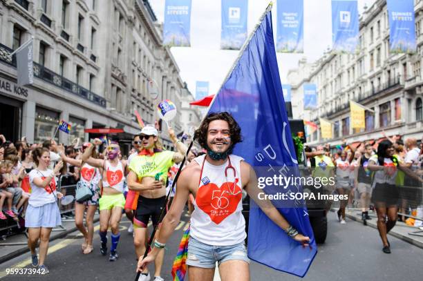 Marcher representing London sexual health clinic 56 Dean Street carries a flag along Regent Street during the 2017 Pride in London Parade through the...