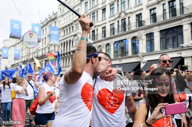 Marchers representing London sexual health clinic 56 Dean Street kiss Regent Street during the 2017 Pride in London Parade through the West End. The...