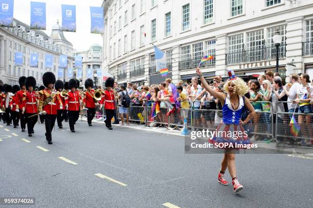 Participant in Stars and Stripes fancy dress marches ahead of the British Army's Band of the Welsh Guards on Regent Street during the 2017 Pride in...