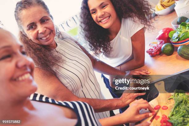 grandmother, mother and child cooking in the kitchen. - aboriginal girl stock pictures, royalty-free photos & images