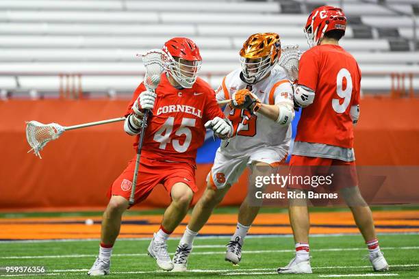 Clarke Petterson of the Cornell Big Red dodges to the goal against the defense of Marcus Cunningham of the Syracuse Orange during a 2018 NCAA...