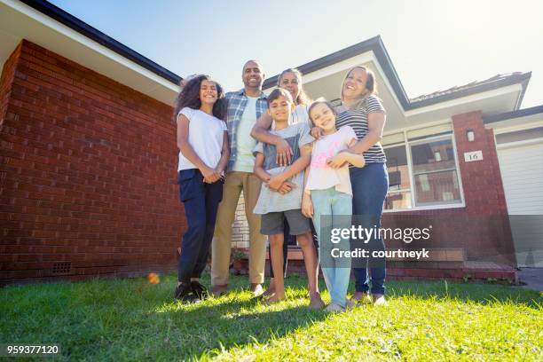 aboriginal family standing in front of their home. - aboriginal family stock pictures, royalty-free photos & images