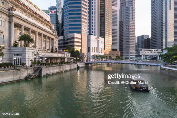 tourboat on singapore river in business district, singapore - シンガポール川 ストックフォトと画像