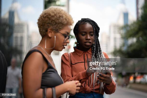 two businesswoman get directions on mobile - cell phone confused stock pictures, royalty-free photos & images