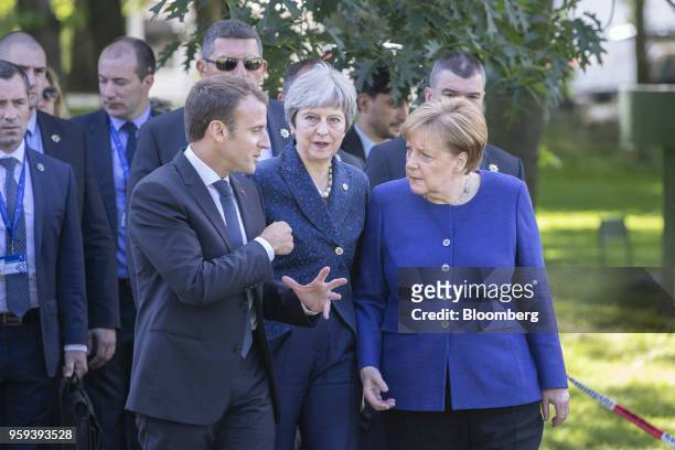 Emmanuel Macron, France's president, left, Theresa May, U.K. Prime minister, center, and Angela Merkel, Germany's chancellor, walk in the gardens of...