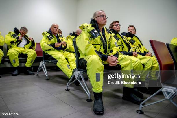 Eldar Saetre, chief executive officer of Equinor ASA, center, listens to a briefing before boarding a helicopter on route to the Troll A natural gas...