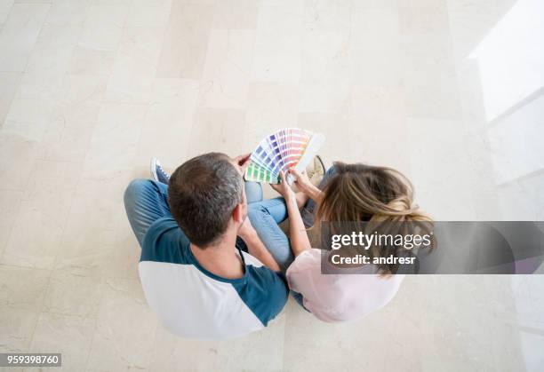 couple choosing a color to paint their house - choosing paint stock pictures, royalty-free photos & images