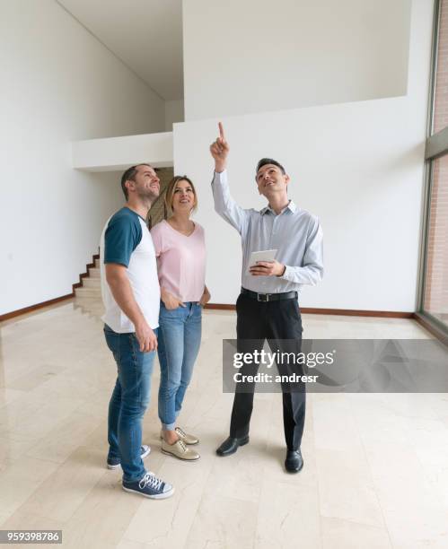 real estate agent showing a property to a couple - house showing stock pictures, royalty-free photos & images