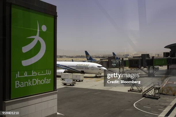 An advertisement for Bank Dhofar SAOG sits on display in the passenger terminal at Muscat International Airport in Muscat, Oman, on Monday, May 7,...