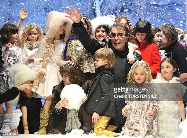 Italian designer Roberto Cavalli poses with children at the end of his fashion show for the labels "Roberto Cavalli Angels" and "Roberto Cavalli...